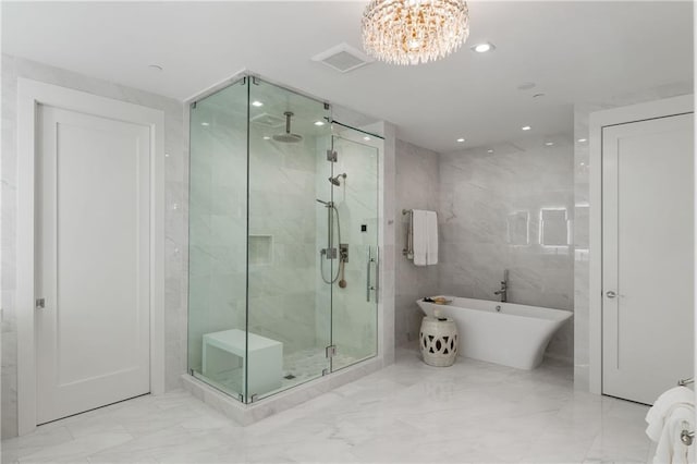 3107 Peachtree Rd NE Unit 1403, Atlanta, GA 30305 - bathroom with tile walls, a soaking tub, a chandelier, a shower stall, and marble finish floor