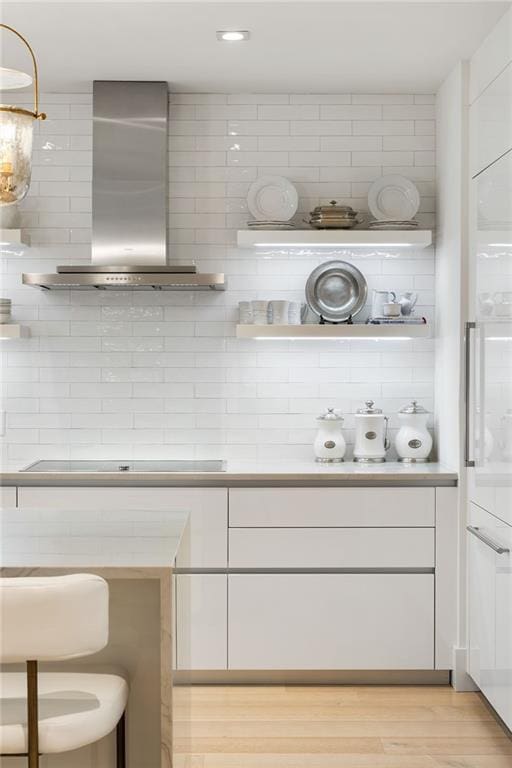 3107 Peachtree Rd NE Unit 1403, Atlanta, GA 30305 - interior space with wall chimney range hood, recessed lighting, black electric stovetop, backsplash, and light wood-style flooring