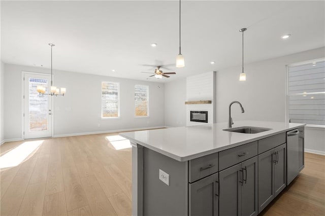 714 Smokey Quartz Way, Kennesaw, GA 30144 - kitchen with a sink, gray cabinetry, light countertops, open floor plan, and a fireplace