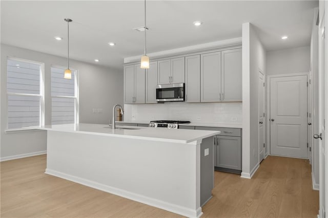 714 Smokey Quartz Way, Kennesaw, GA 30144 - kitchen featuring gray cabinets, stainless steel microwave, a sink, stove, and light wood finished floors