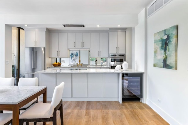 2575 Peachtree Rd NE Unit 6G, Atlanta, GA 30305 - kitchen featuring wine cooler, appliances with stainless steel finishes, light wood-style flooring, baseboards, and recessed lighting