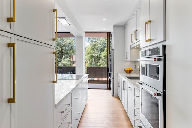 2575 Peachtree Rd NE Unit 6G, Atlanta, GA 30305 - kitchen with white refrigerator, double oven, light countertops, a wall of windows, and light wood finished floors