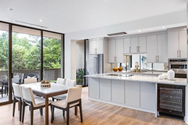 2575 Peachtree Rd NE Unit 6G, Atlanta, GA 30305 - kitchen with wine cooler, expansive windows, a sink, healthy amount of natural light, and light stone counters