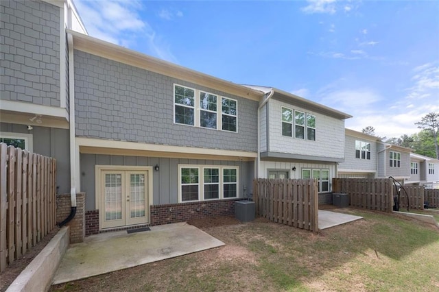 1025 Cherryfield Run, Marietta, GA 30008 - back of house featuring board and batten siding, french doors, a patio area, central AC unit, and brick siding