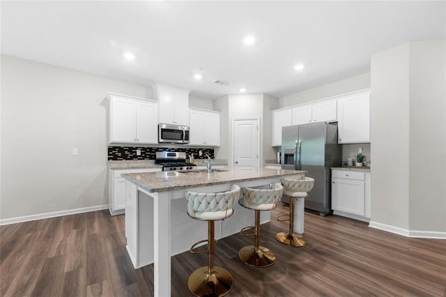 1025 Cherryfield Run, Marietta, GA 30008 - kitchen featuring stainless steel appliances, a kitchen island with sink, dark wood finished floors, baseboards, and recessed lighting