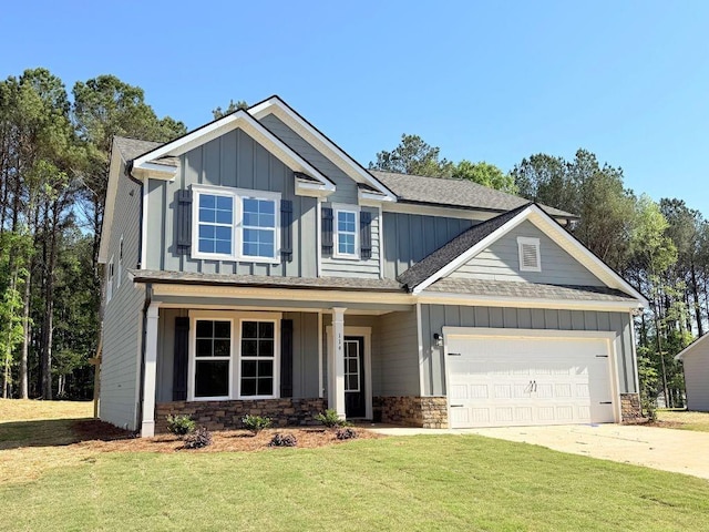 craftsman house featuring a front lawn, driveway, stone siding, a garage, and board and batten siding