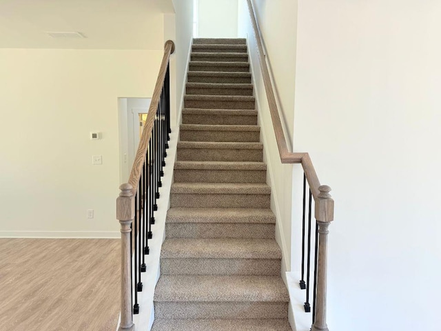 stairway with baseboards and wood finished floors