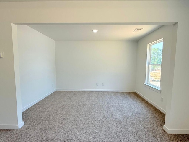 carpeted empty room featuring visible vents and baseboards
