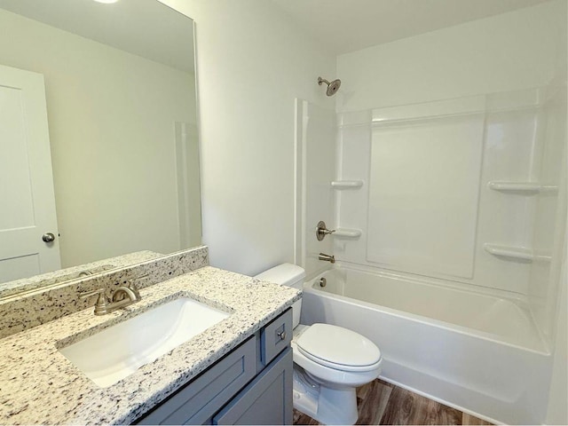 bathroom featuring toilet, shower / bathtub combination, vanity, and wood finished floors