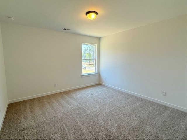 carpeted empty room with visible vents and baseboards