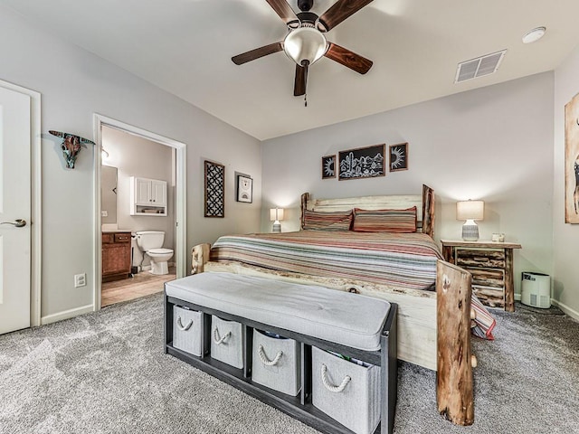 carpeted bedroom with connected bathroom and ceiling fan