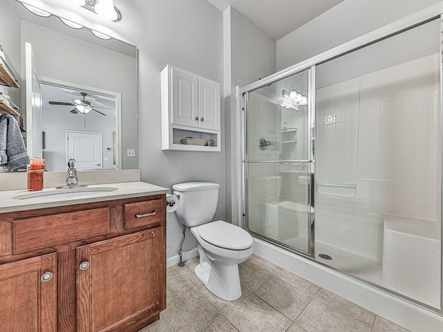 bathroom featuring walk in shower, tile patterned floors, toilet, vanity, and ceiling fan