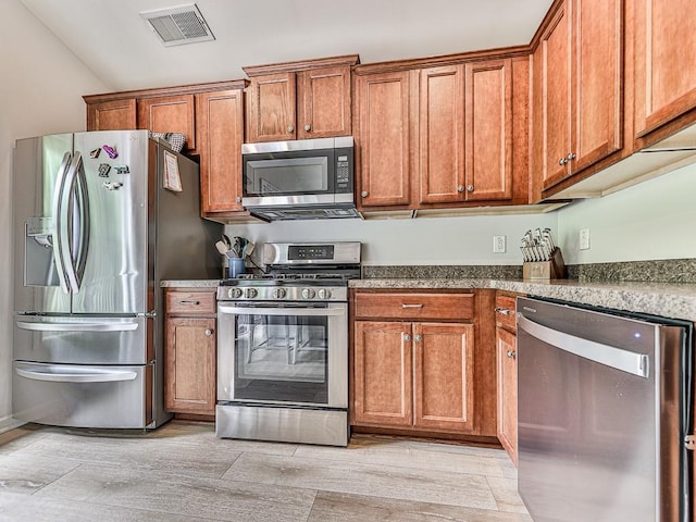 kitchen featuring vaulted ceiling and stainless steel appliances