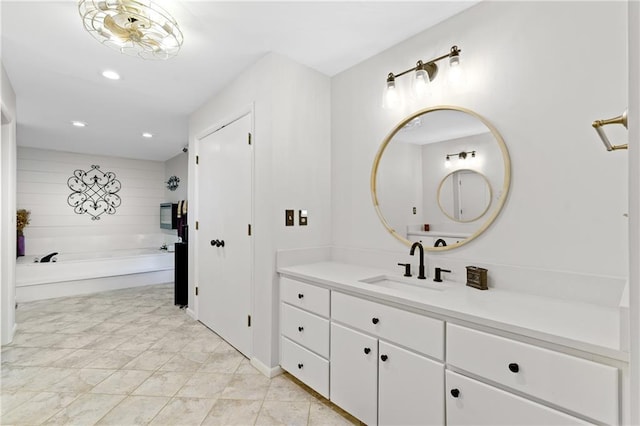 full bathroom with recessed lighting, a bath, and vanity