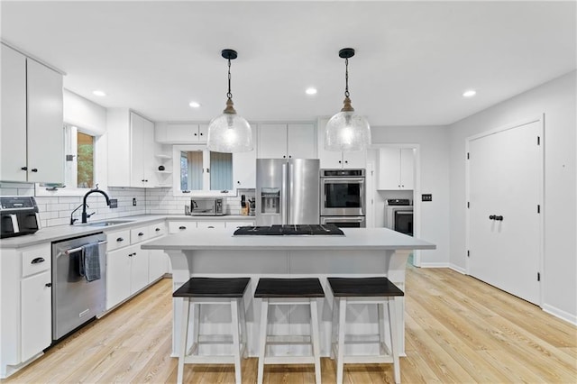 kitchen featuring light countertops, stainless steel appliances, a sink, and a kitchen bar