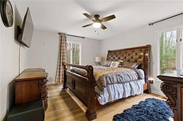 bedroom with baseboards, ceiling fan, and light wood finished floors