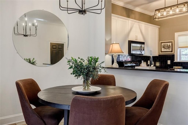 dining room featuring a notable chandelier and ornamental molding