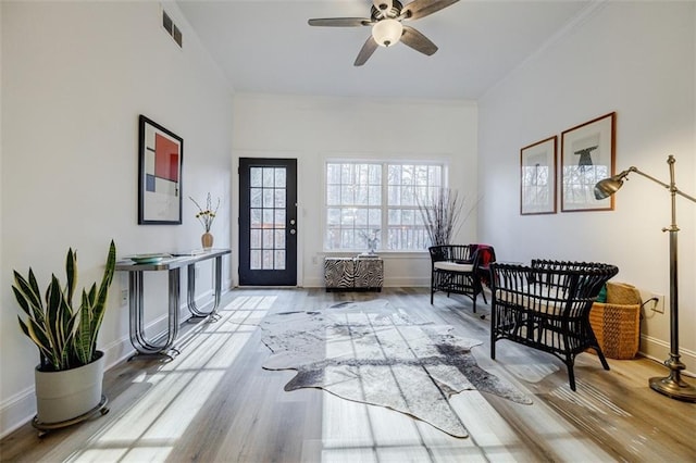 living area with ceiling fan and light hardwood / wood-style flooring