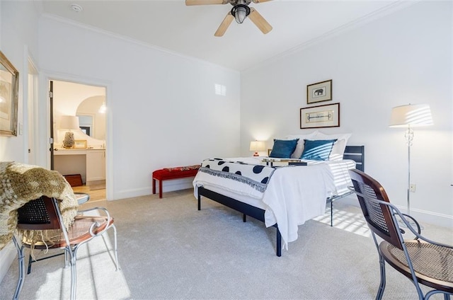 carpeted bedroom featuring ornamental molding, connected bathroom, and ceiling fan