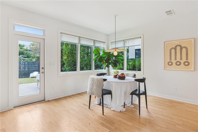 dining room with visible vents, baseboards, and wood finished floors