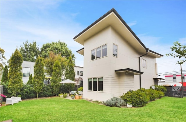 rear view of property with a lawn and fence