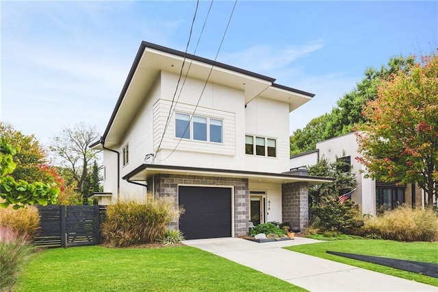 modern home with a front lawn, stone siding, fence, concrete driveway, and a garage