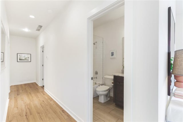 corridor with visible vents, recessed lighting, baseboards, and light wood-style floors