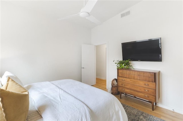 bedroom featuring ceiling fan, visible vents, and wood finished floors