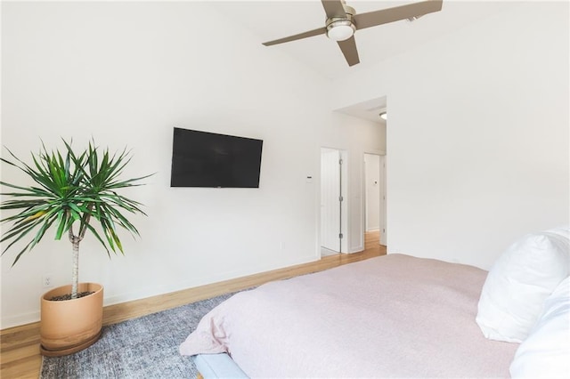 bedroom with baseboards, wood finished floors, and a ceiling fan