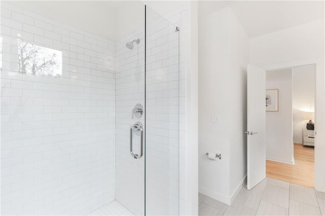 full bath featuring a stall shower and baseboards