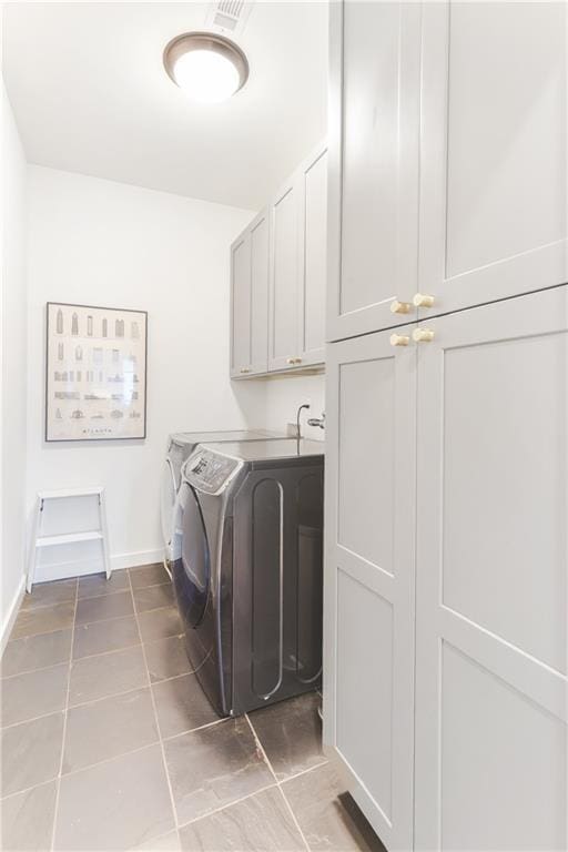 laundry room with baseboards, visible vents, cabinet space, separate washer and dryer, and tile patterned floors