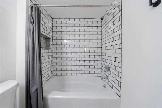 bathroom featuring toilet and shower / tub combo with curtain