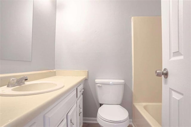 bathroom featuring toilet, baseboards, a bathtub, walk in shower, and vanity