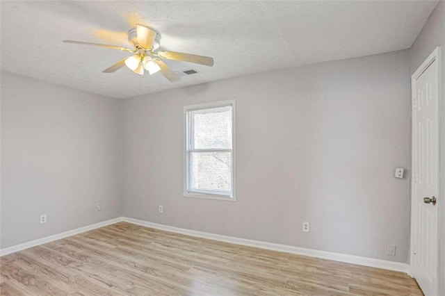 unfurnished room featuring light wood-style flooring, a textured ceiling, baseboards, and ceiling fan