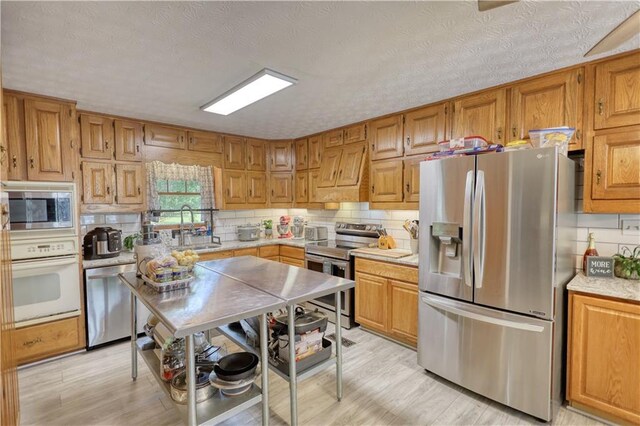 78 N Pomona Rd, Hampton, GA 30228 - kitchen featuring stainless steel appliances, custom exhaust hood, a sink, light wood-style floors, and backsplash