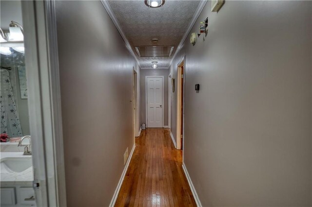 78 N Pomona Rd, Hampton, GA 30228 - hall featuring attic access, crown molding, hardwood / wood-style floors, baseboards, and a sink
