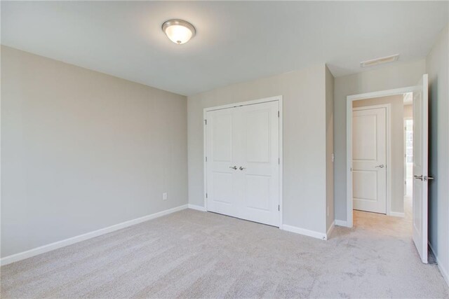 unfurnished bedroom featuring ceiling fan, crown molding, light colored carpet, and a spacious closet