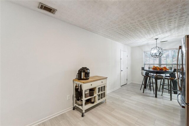 dining space featuring light hardwood / wood-style flooring and an inviting chandelier