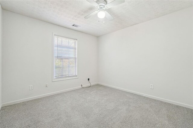 carpeted spare room with a textured ceiling and ceiling fan