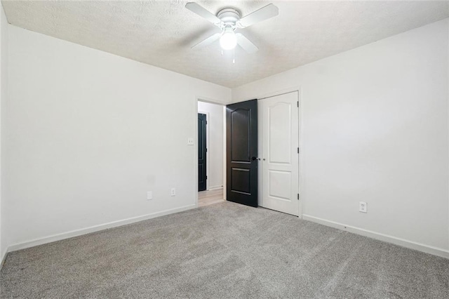 unfurnished bedroom with a textured ceiling, light colored carpet, and ceiling fan