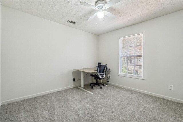 unfurnished office with ceiling fan, carpet, and a textured ceiling