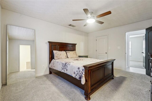 carpeted bedroom featuring ceiling fan and a textured ceiling