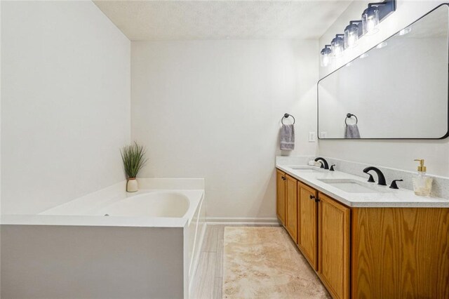 bathroom featuring vanity, a bath, and a textured ceiling