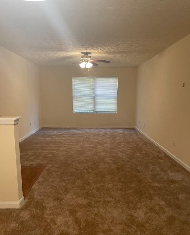 carpeted empty room featuring a textured ceiling and ceiling fan