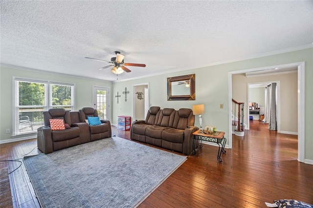 2196 Kildare Way NW, Kennesaw, GA 30152 - living room with a textured ceiling, crown molding, a ceiling fan, dark wood-style flooring, and stairs