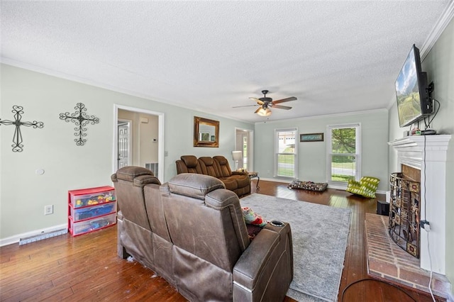 2196 Kildare Way NW, Kennesaw, GA 30152 - living area with ornamental molding, a textured ceiling, a brick fireplace, a ceiling fan, and wood finished floors