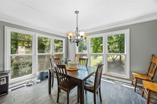 2196 Kildare Way NW, Kennesaw, GA 30152 - dining space with a chandelier, crown molding, dark wood-style floors, healthy amount of natural light, and a textured ceiling