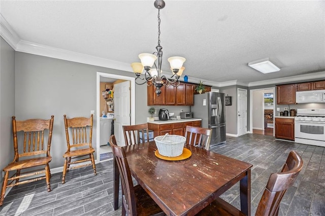 2196 Kildare Way NW, Kennesaw, GA 30152 - dining area featuring washer / dryer, a textured ceiling, crown molding, a chandelier, and baseboards