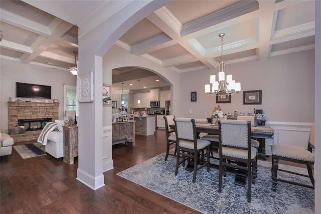 295 Hanover Dr, Villa Rica, GA 30180 - dining room with coffered ceiling, a stone fireplace, ceiling fan, beamed ceiling, and dark wood-type flooring