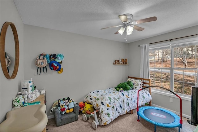 carpeted bedroom featuring ceiling fan and a textured ceiling